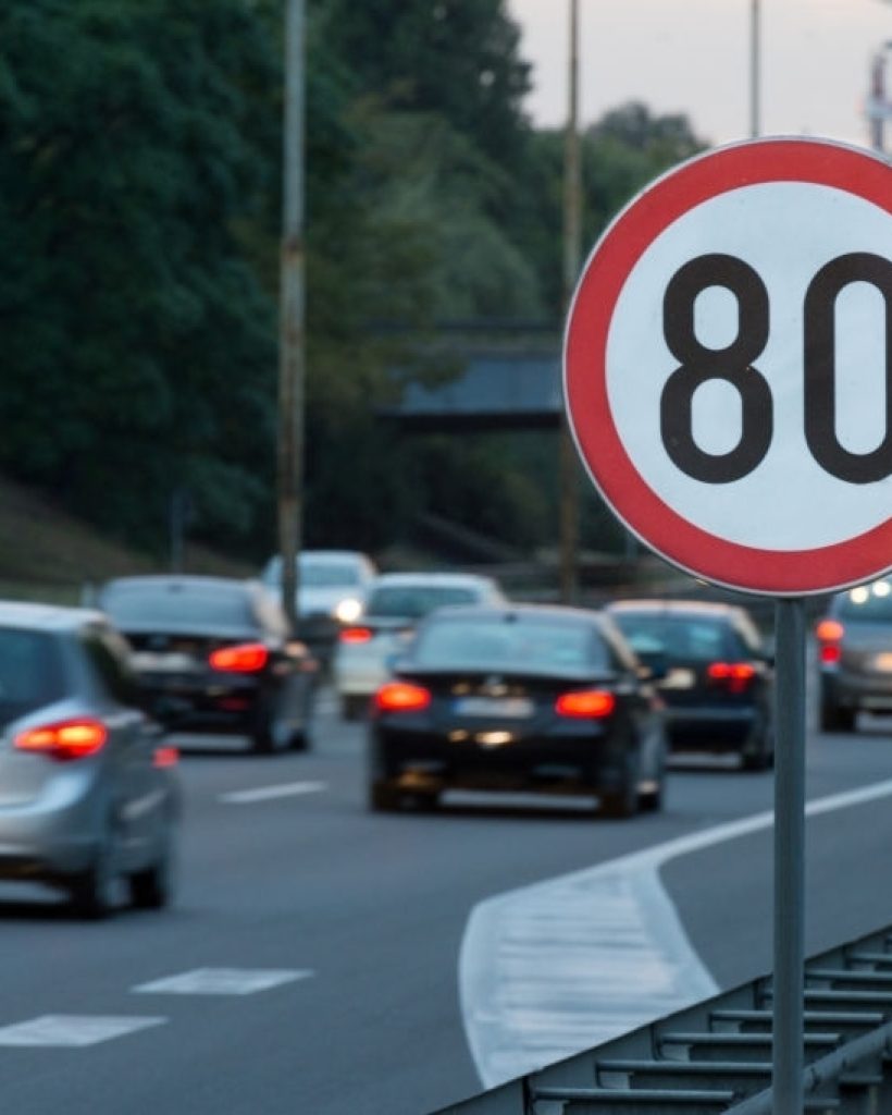 Speed limit sign with a traffic in the background